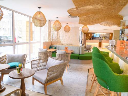 图尔风格旅游中心宜必思酒店的客厅配有绿色椅子和桌子