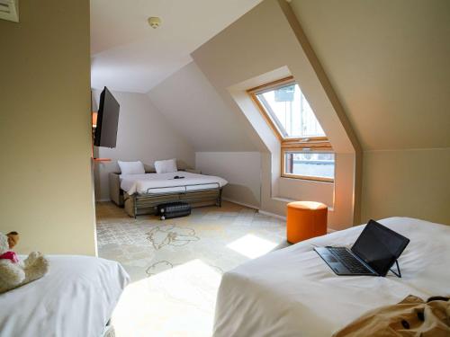 图尔风格旅游中心宜必思酒店的阁楼间设有两张床,配有笔记本电脑