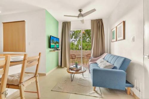 蓬塔卡纳OASIS Punta Cana Apartment的客厅配有蓝色的沙发和桌子