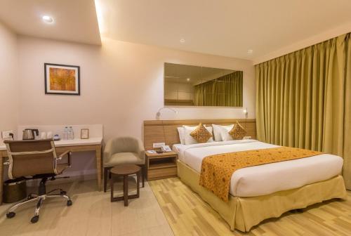 古瓦哈提Hotel Palacio的配有一张床和一张书桌的酒店客房