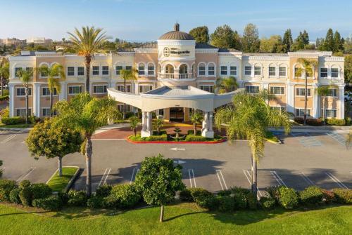 安纳海姆Hotel Marguerite South Anaheim - Garden Grove, Trademark Collection by Wyndham的享有棕榈树大建筑的空中景致