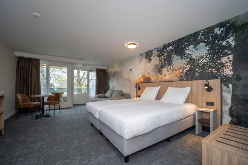 罗登弗莱彻酒店的卧室配有白色的床和墙上的绘画作品