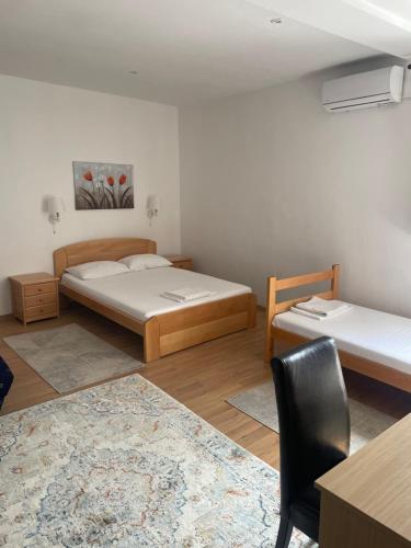 贝尔格莱德Apartments & Rooms L E F T RIVER Belgrade的一间卧室配有两张床、一张桌子和一把椅子