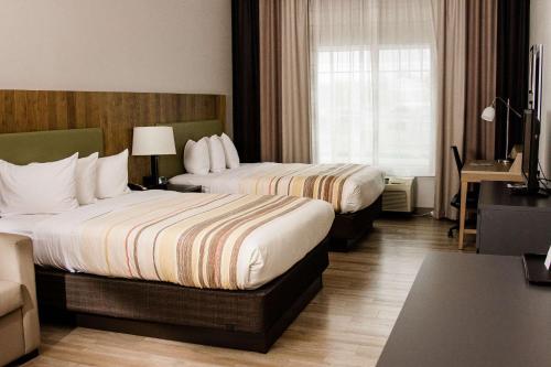 温彻斯特温彻斯特乡间酒店的酒店客房设有两张床和窗户。