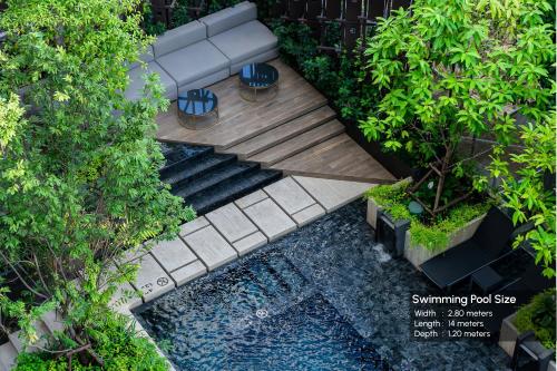 曼谷Gardina Asoke Hotel & Residence - SHA Certified的享有花园的顶部景色,设有长凳和水