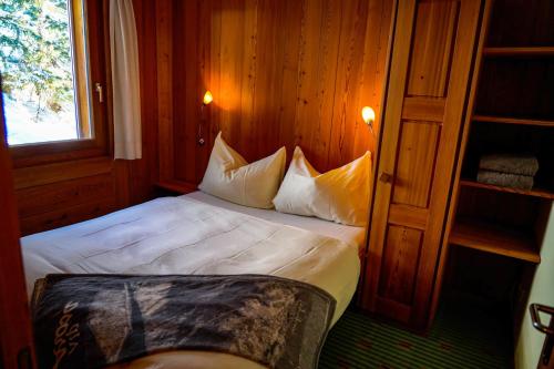 阿罗萨Seeblick的一间卧室配有带白色床单和枕头的床。