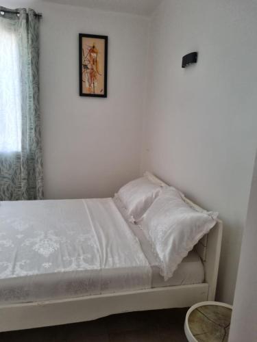 索蒙La villa Lisbonne的一张铺有白色床单的床和一张墙上的照片