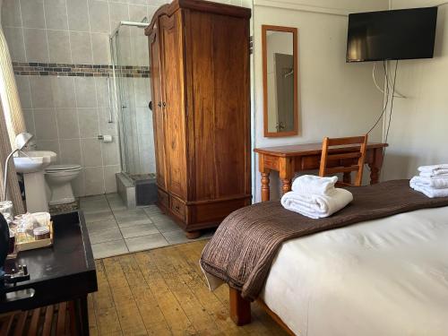 比勒陀利亚Pebble Fountain Guesthouse的一间卧室配有一张床,浴室设有淋浴。