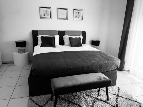 卢森堡LUXURY PENTHOUSE APARTMENT WITH 3 Balconies -2 BEDROOMS & PETRUS VIEW的黑白卧室配有床和椅子