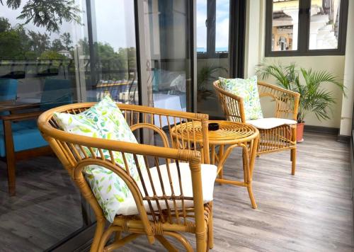 康隆尼角Residence Le Point Choisy的庭院设有藤椅、桌子和窗户。