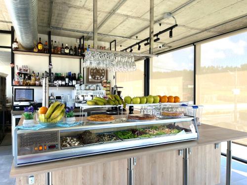 卡马里尼亚斯Hospedium Hotel Devalar Do Mar的自助餐,包括水果和蔬菜在柜台上