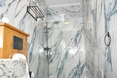 波多诺伏Freedom Palace Hôtel的一间设有大理石墙淋浴的浴室