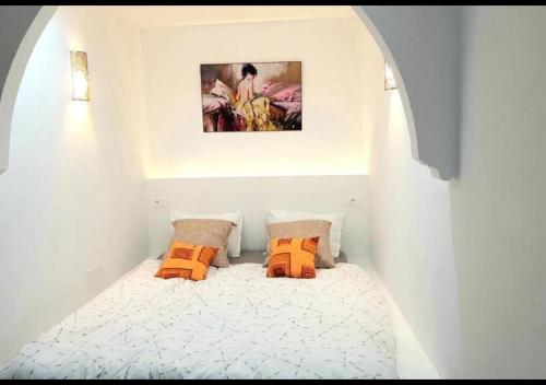 拉马萨The Arabesque House的一间小卧室,配有带橙色枕头的床