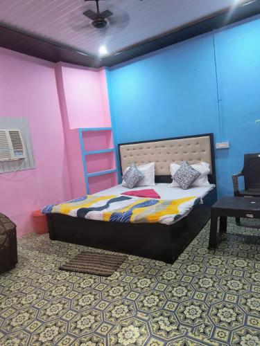瓦拉纳西Goroomgo Rainbow Residency Varanasi Near By Assi Ghat River - Excellent Service的一间卧室配有一张床和粉红色和蓝色的墙壁