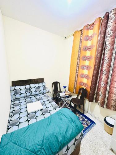 阿布扎比MKB APARTMENTS的一间卧室配有一张床、两把椅子和一个窗户