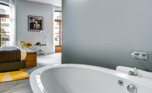 蒙特利尔格特酒店的一间带白色浴缸和床的浴室