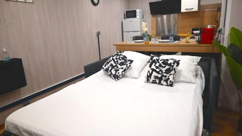 Villeneuve-sous-DammartinStudio/2 voyageurs/10mn CDG的卧室配有白色的床和枕头。