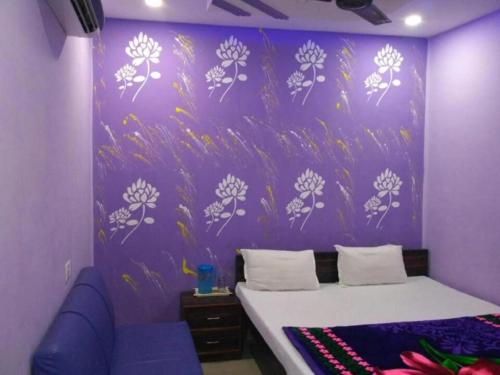 坎普尔Hotel Atithi Galaxy Kanpur Near Railway Station Kanpur - Wonderfull Stay with Family的紫色卧室,配有一张床和紫色的墙壁