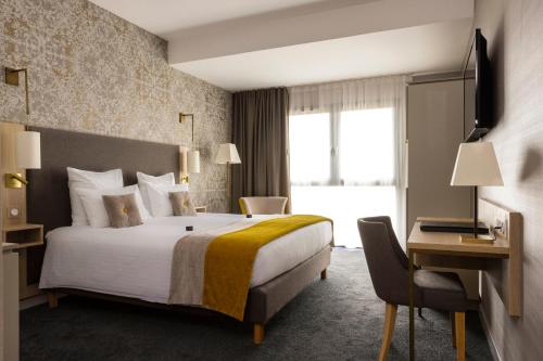 科尔马James Boutique Hôtel Colmar centre的酒店客房设有一张大床和一张书桌。