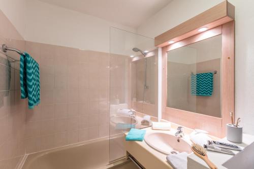 圣马克西姆皮埃尔法国梧桐假日酒店的一间带水槽、浴缸和镜子的浴室