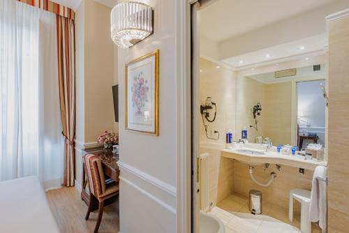 佛罗伦萨FH55 Hotel Calzaiuoli的一间带水槽和镜子的浴室