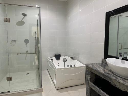 乌约Vinpy hotels的带淋浴和盥洗盆的白色浴室