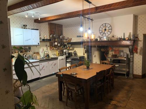 La Barthe-de-NesteL'AUBERGE DES PYRENEES的一个带木桌和椅子的大厨房
