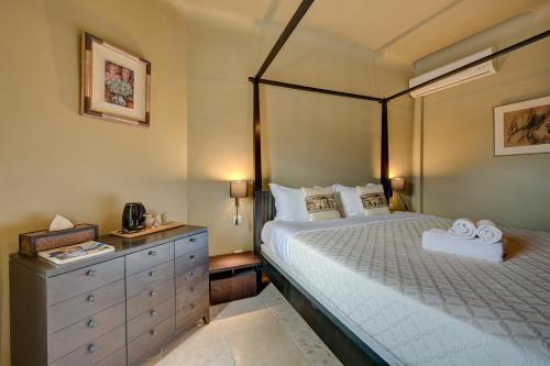卢马罕帕拉多酒店的一间卧室配有床和带毛巾的梳妆台。