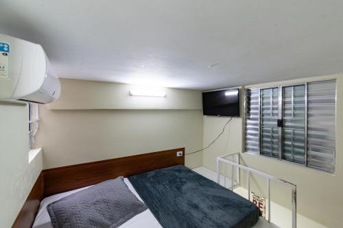 圣保罗38 LOFT DUPLO · LOFT perto da São PauloExpo /Aeroporto Congonhas的小房间设有床和电视