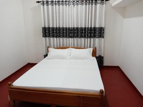 UreluWhiterock Villa的卧室配有带窗帘的白色床