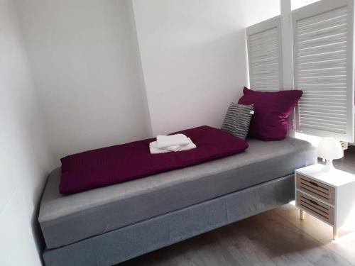 桑德Villa Mariensiel 2OG li的紫色枕头的床上