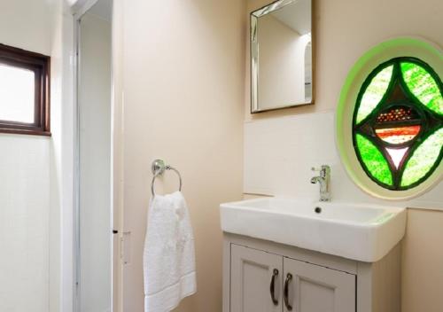 雷文格拉斯Irt Pullman Carriage的一间带水槽和彩色玻璃窗的浴室