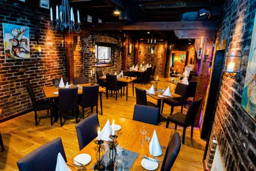巴特明斯特艾弗尔兰德嘎斯豪斯斯坦恩穆尔酒店的餐厅设有木桌、椅子和砖墙