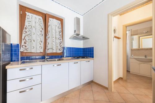 特雷莫西内Residence Tatiana A4的厨房配有白色橱柜和水槽