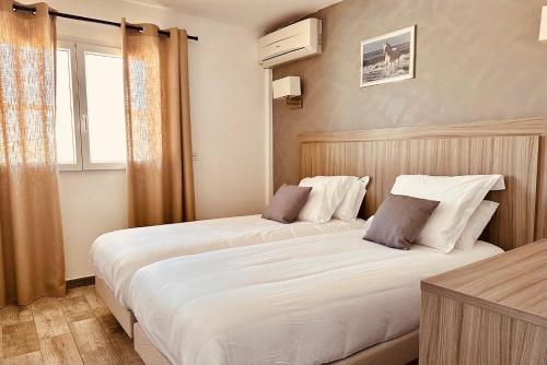 圣马迪拉莫卡马格棕榈酒店的配有窗户的酒店客房内的两张床