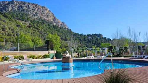 埃斯塔蒂特Apartamentos La Masia的山前带雕像的游泳池