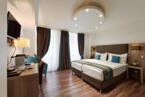 日内瓦卢梭酒店的酒店客房设有一张大床和一张书桌。