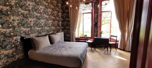 WaaxensPastorie Waaxens的一间卧室设有一张床和鲜花墙