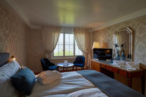 穆尔滕希夫阿姆西酒店的一间卧室配有一张床、一张书桌和一台电视