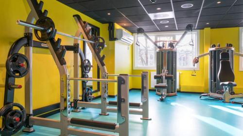 奥斯陆Thon Hotel Europa的一间设有数台跑步机的健身房,位于黄色的房间