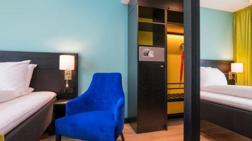 奥斯陆Thon Hotel Europa的酒店客房带蓝色椅子和一张床