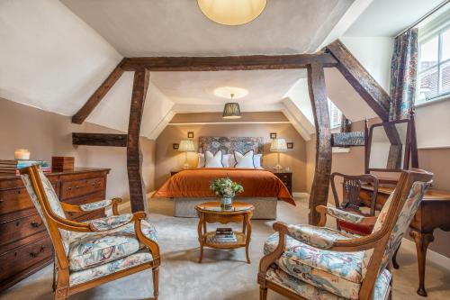 温彻斯特Avington Estate的一间卧室配有一张大床和两把椅子