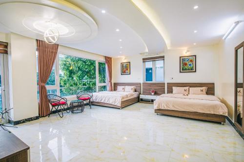 岑山Mai Linh Villa - FLC Sam Son的一间卧室配有两张床和一张桌子及椅子