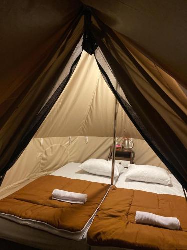KejajarSunCampGround Glamping的帐篷内的一张床位,上面有两条毛巾