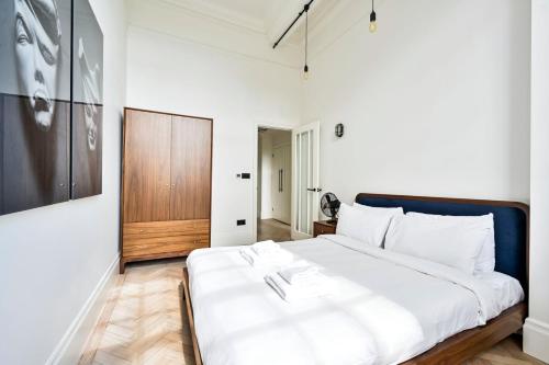 帕尔默斯格林GuestReady - Luxury haven in Palmers Green的卧室配有白色的床和木门