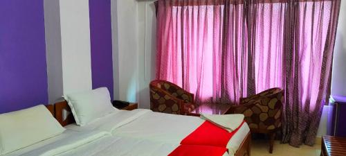 钦奈Manhattan的一间卧室配有床和一个带粉红色窗帘的窗户。