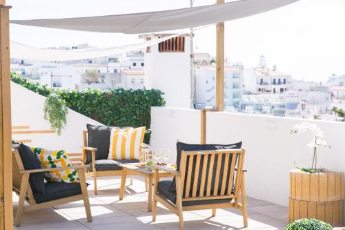 阿尔布费拉Golden Stay - B&B Experience的阳台的天井配有桌椅