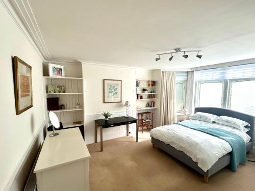伦敦East Finchley N2 apartment close to Muswell Hill & Alexandra Palace with free parking on-site的一间卧室配有一张床和一张书桌