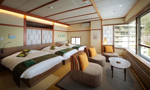 仙台作并温泉沙龙位置墓酒店的酒店客房,设有两张床和一张沙发