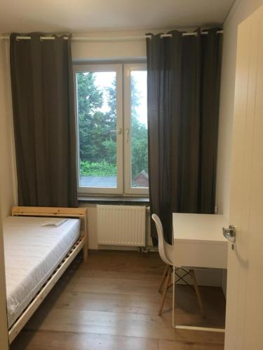 弗罗茨瓦夫Hallera Wroclaw的一间卧室配有一张床、一张书桌和一个窗户。